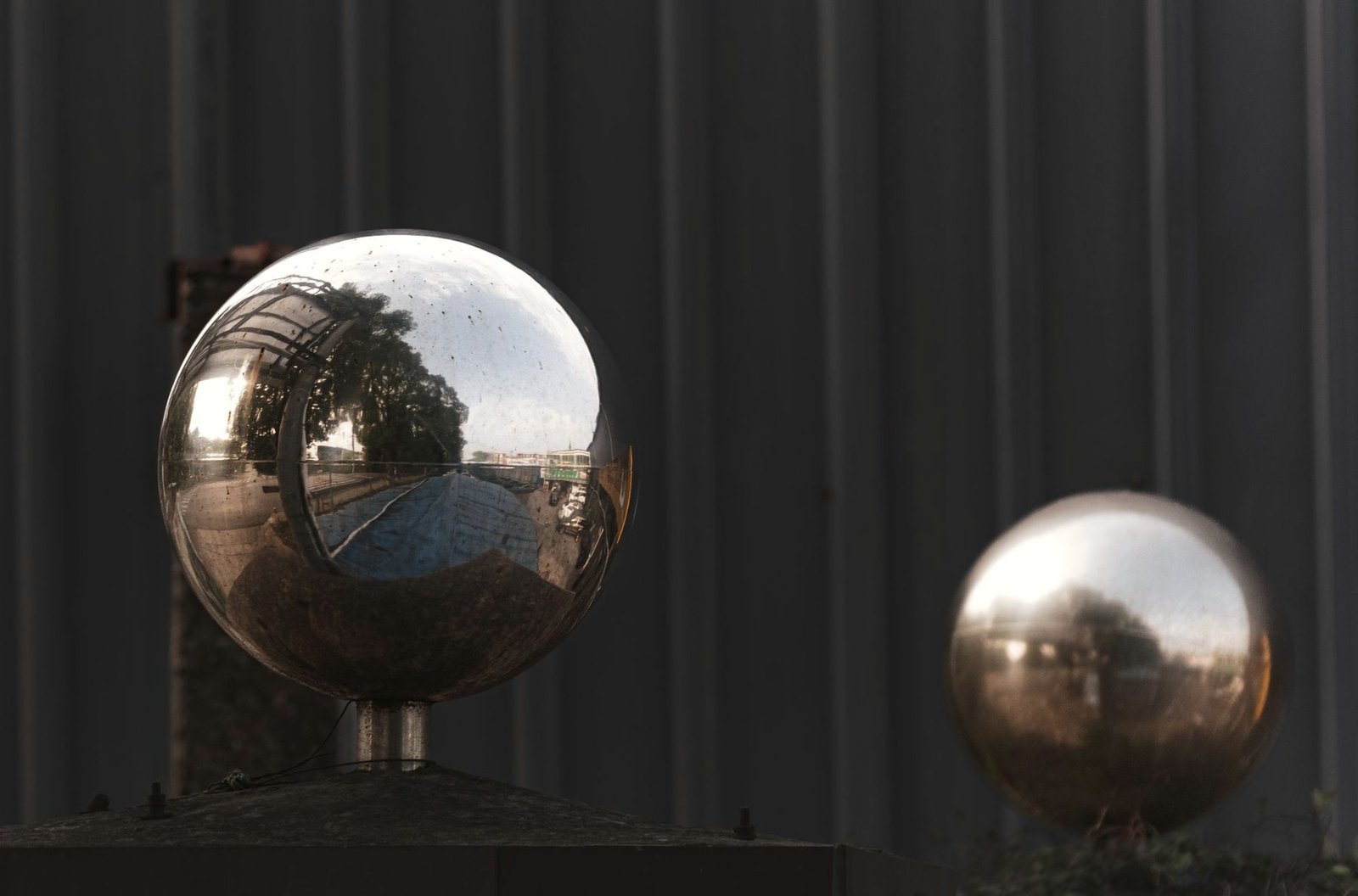 Two mirrored metal spheres reflecting their surroundings.