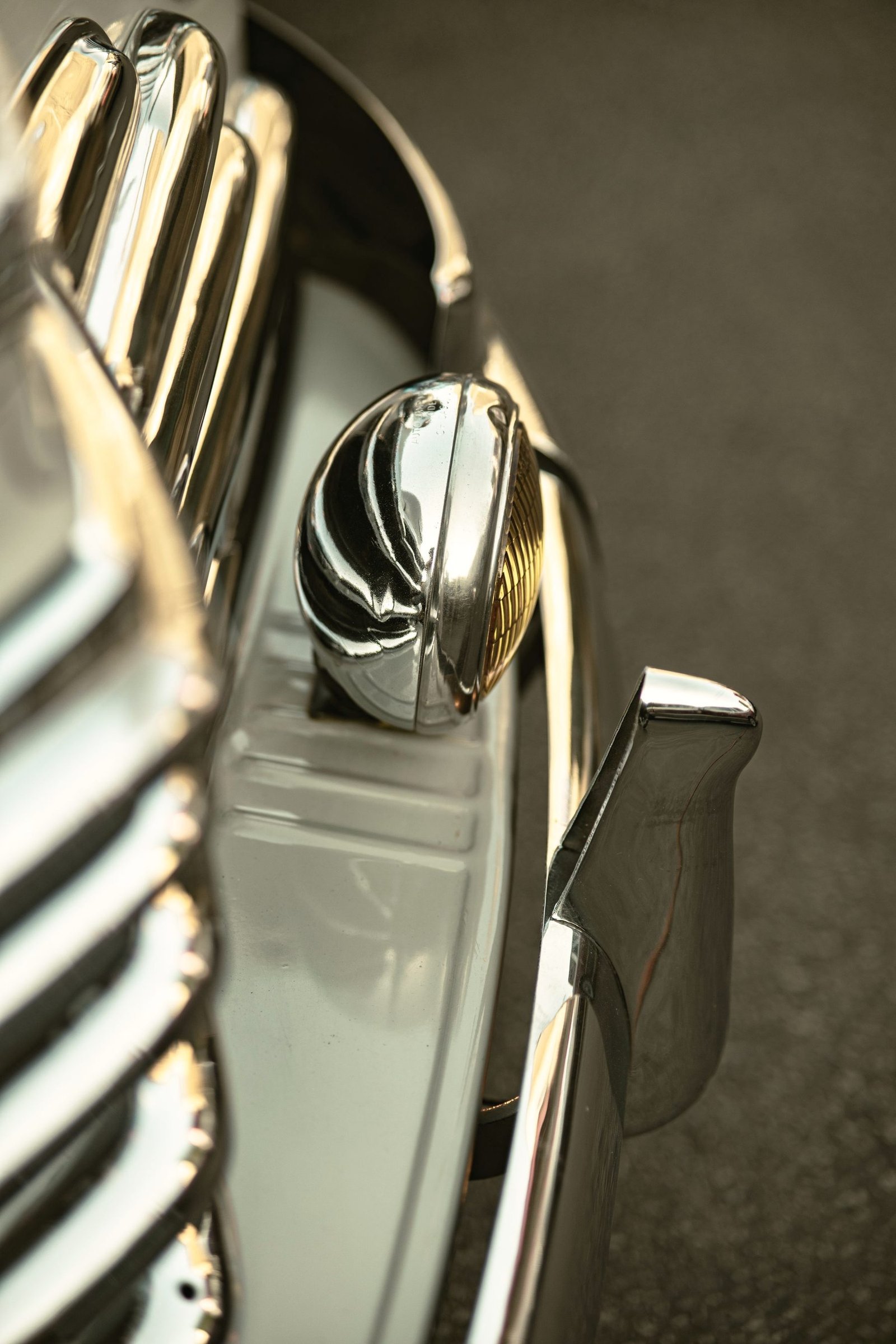 A chrome fitting on a classic car, polished to a mirror finish.